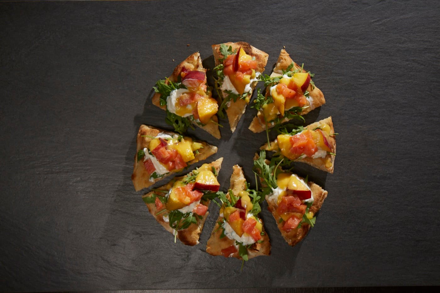 Pizza “impasto evolutiva” con tartare di salmone Upstream, burrata, pesche ed erba cipollina